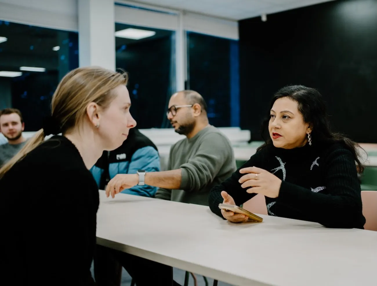 International professionals talking with a local over coffee